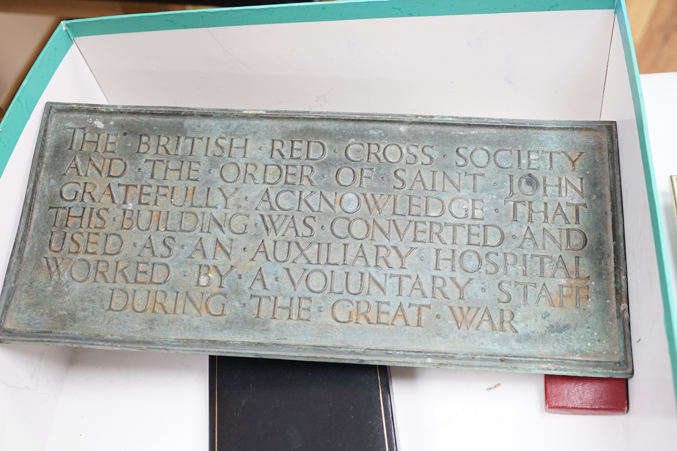 A collection of British Red Cross, medals, badges and memorabilia including a brass plaque, commemorating an auxiliary hospital during the Great War, proficiency, medals, long, service, medals, metal boxes, and some pape